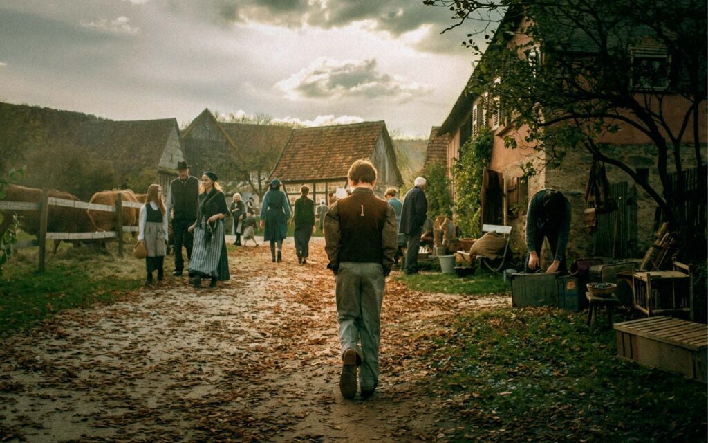 Revived (2018) – Set Design for commercial short film, rural village street in the 1930s with townspeople, timber houses and a boy walking along muddy path, dramatic sky