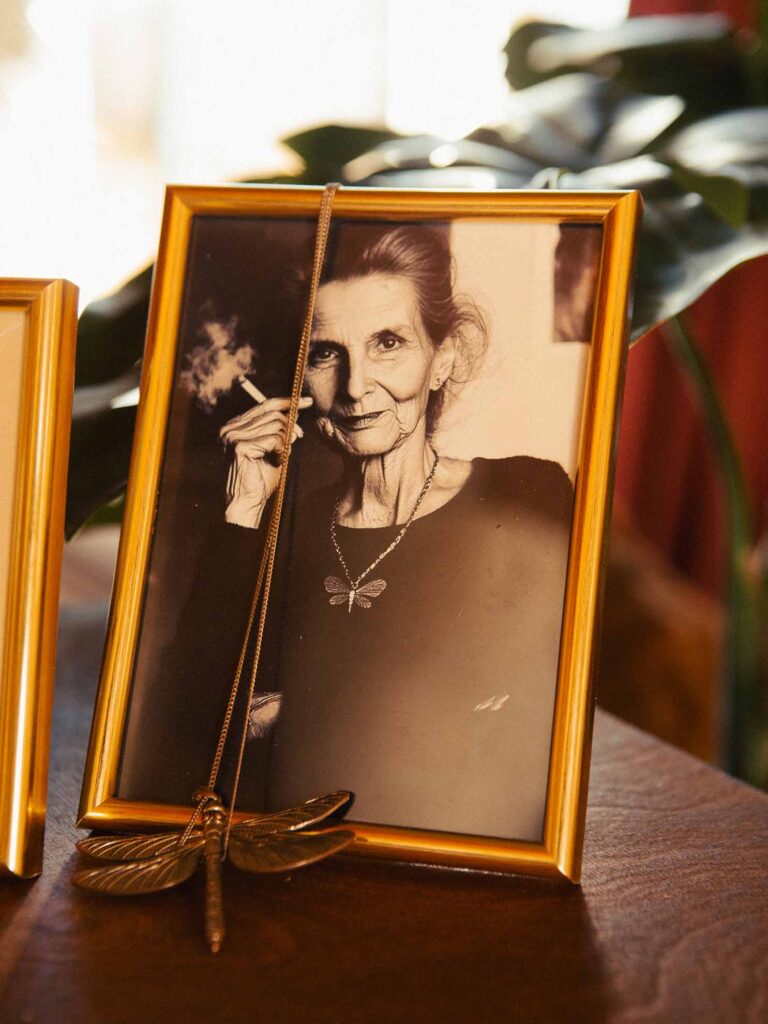 Picobello (2026) – Behind the Scenes Still - production design Picobello (2026) – Production Design for short film, framed portrait of elderly woman, dragonfly pendant draped across, intimate altar-like scene