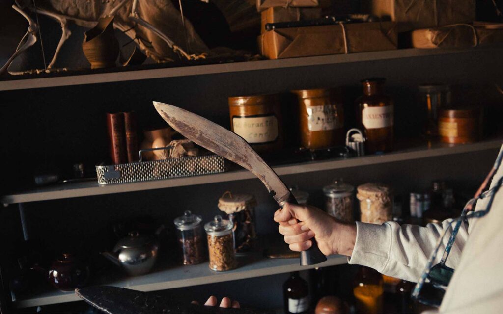 Picobello (2022) – Behind the Scenes Still - production design Picobello (2026) – Production Design for short film, shelves filled with jars, wrapped packages, bottles and odd objects, curated curiosity display
