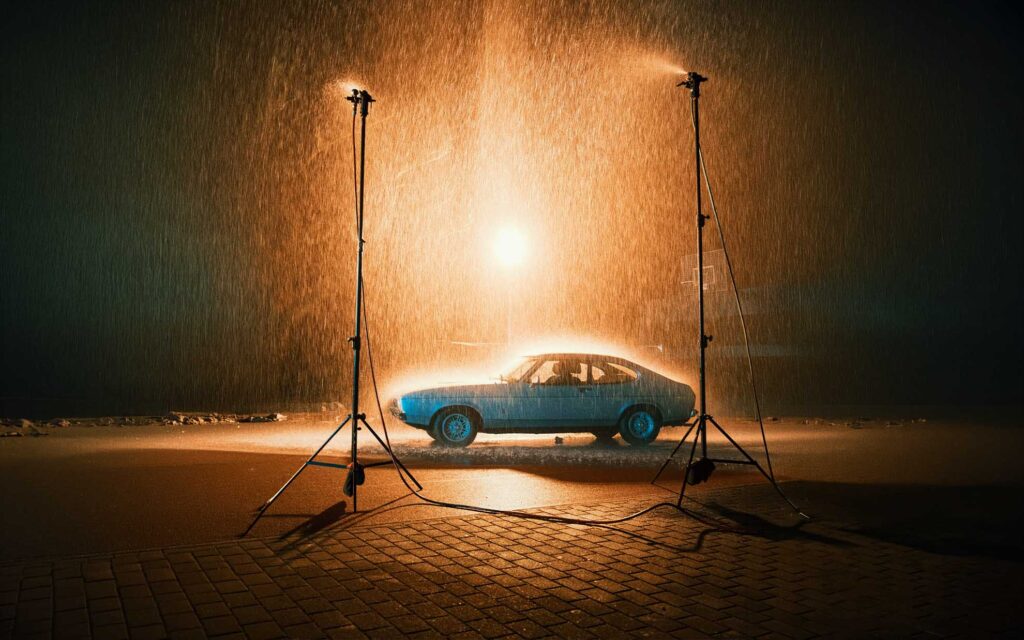 Sweet Will (2026) – Production Design for short film, vintage car in artificial rain, strong backlight, cinematic noir mood, dramatic, surreal night scene